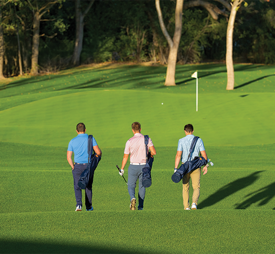 Three guys walking to the next golf hole 