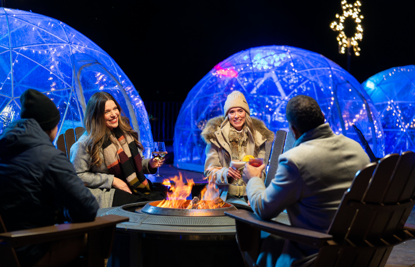 mv_A group of friends by a fire outside of an igloo