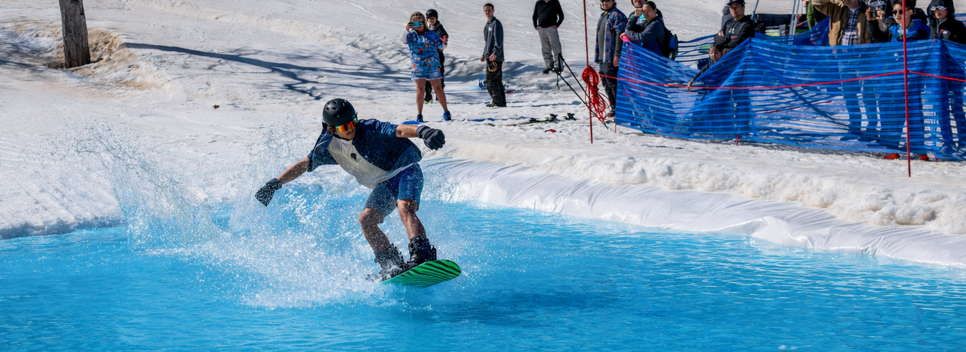 Snowboarder sliding across the pond skim