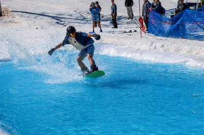 Snowboarder sliding across the pond skim
