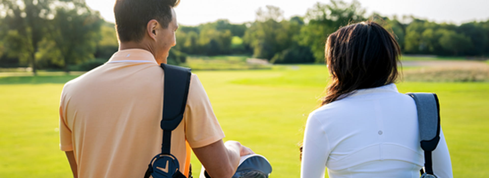 Couple walking with their golf bags