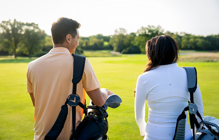 Couple walking with their golf bags