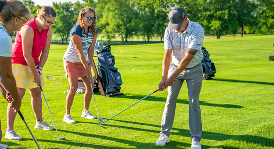 Instructor demonstrating how to swing a golf club