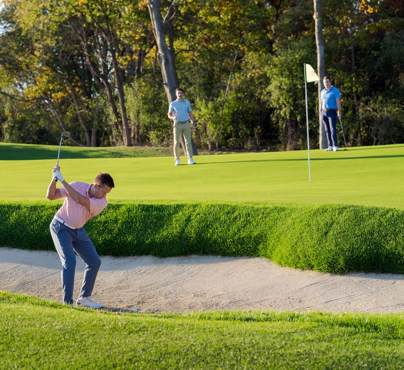 Golfer chipping out of the sand on Wee Nip